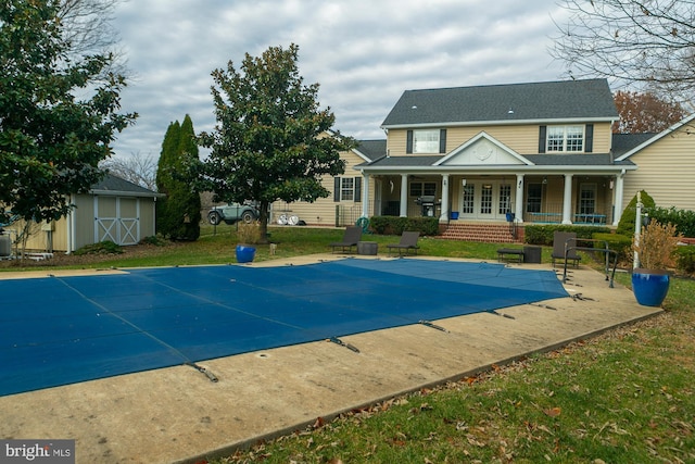 view of swimming pool featuring a lawn, a patio area, and a storage unit