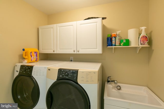 washroom with cabinets and washing machine and clothes dryer