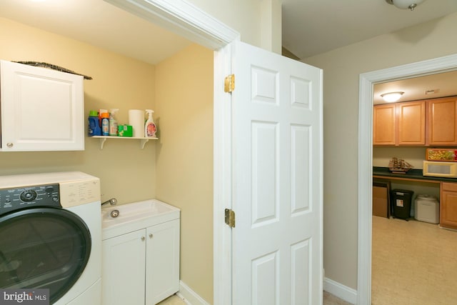 clothes washing area featuring cabinets, washer / dryer, and sink