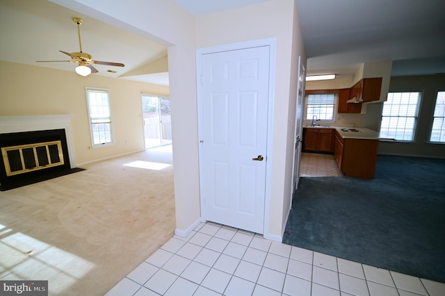 kitchen with light carpet, sink, and ceiling fan