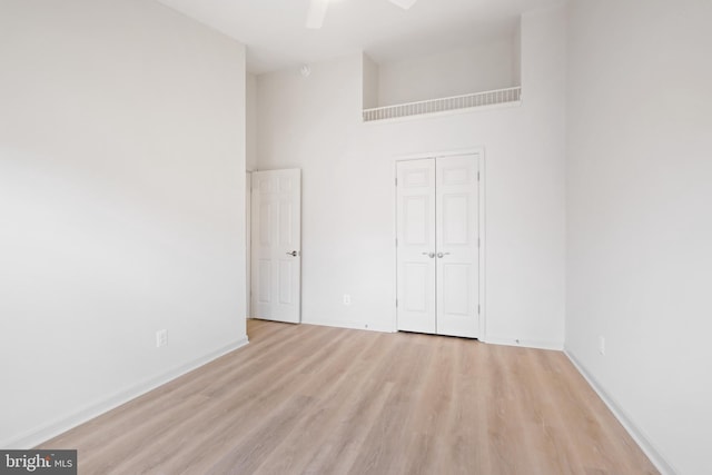 empty room featuring a high ceiling and light hardwood / wood-style flooring