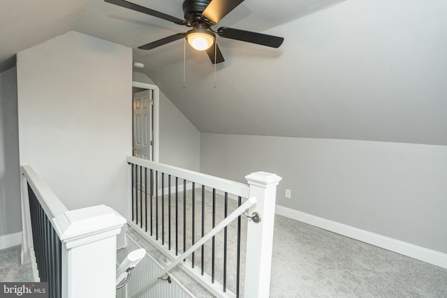 hallway featuring light colored carpet and vaulted ceiling