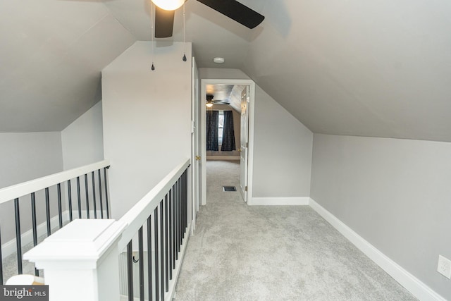 hall featuring light carpet and vaulted ceiling