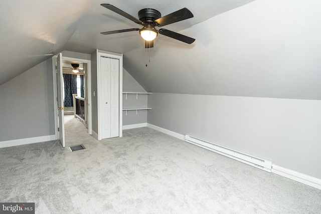 additional living space featuring light colored carpet, baseboard heating, lofted ceiling, and ceiling fan