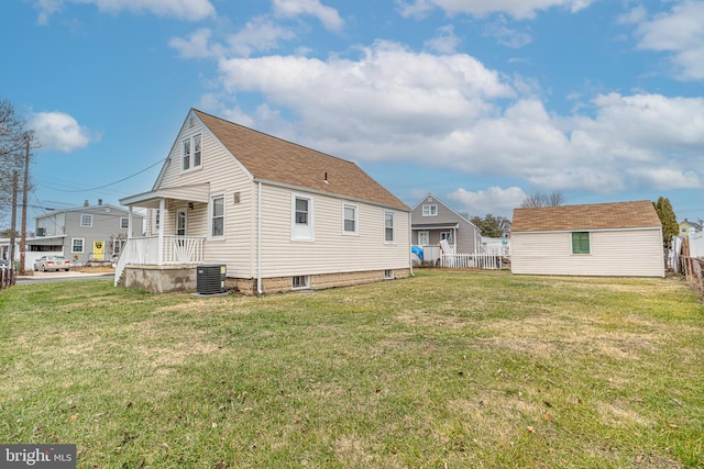 rear view of property with a porch, a yard, and central AC unit