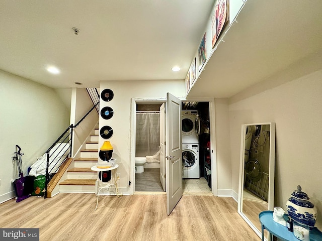 interior space with stacked washing maching and dryer and light hardwood / wood-style floors