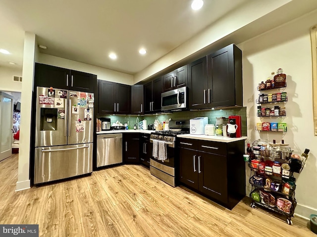 kitchen with tasteful backsplash, light hardwood / wood-style floors, and appliances with stainless steel finishes