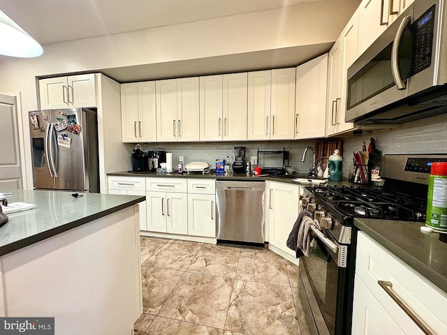 kitchen with white cabinets, stainless steel appliances, tasteful backsplash, and sink