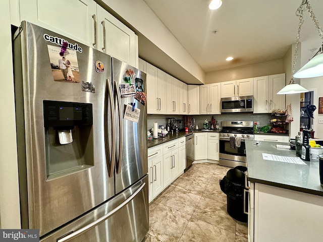 kitchen with white cabinetry, hanging light fixtures, and appliances with stainless steel finishes