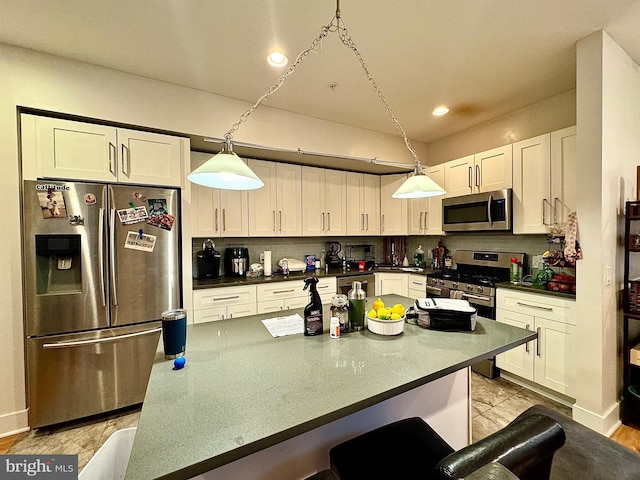 kitchen with stainless steel appliances, pendant lighting, decorative backsplash, a breakfast bar, and white cabinets