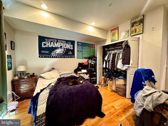 bedroom with wood-type flooring and a closet