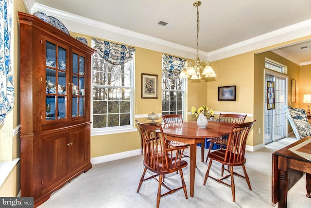 dining area featuring crown molding, light colored carpet, and a chandelier