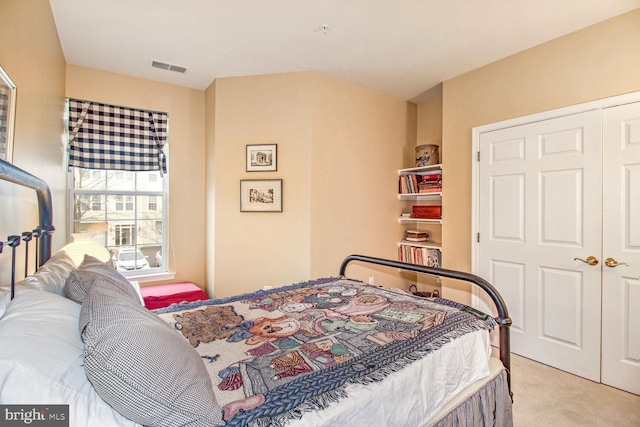 bedroom featuring light carpet and a closet