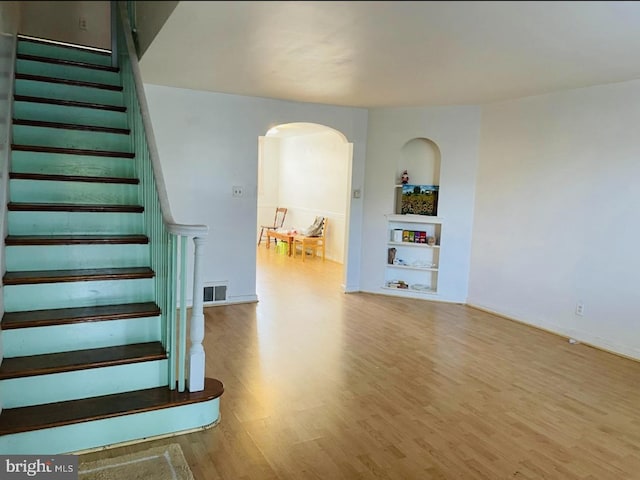 interior space featuring wood-type flooring and built in shelves