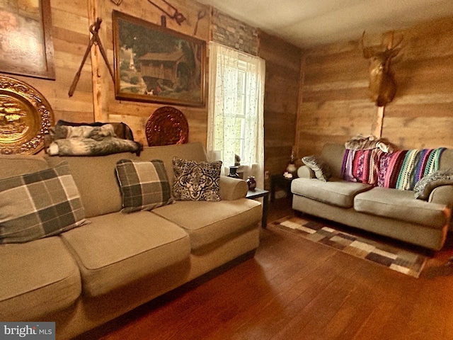 living area with wood-type flooring and wooden walls