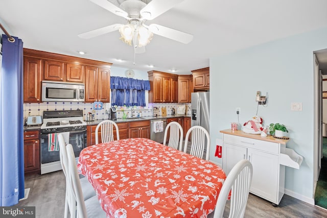 dining room featuring wood-type flooring, ceiling fan, and sink