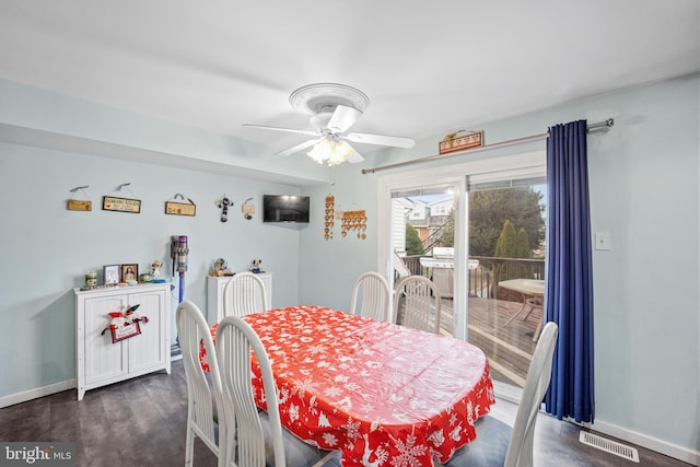 dining space with ceiling fan and dark wood-type flooring