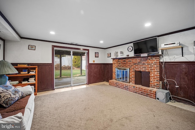 living room with a fireplace, ornamental molding, carpet floors, and wooden walls