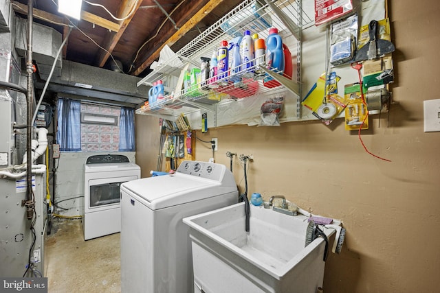 clothes washing area with washing machine and dryer and sink