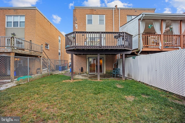 back of property with a lawn, a patio area, and a deck