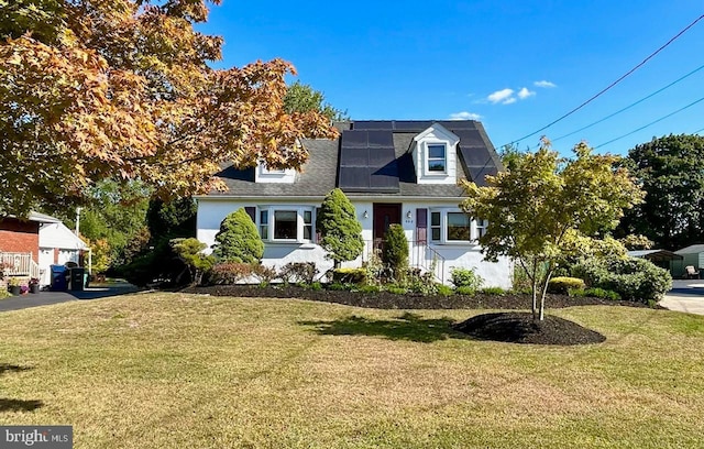 new england style home featuring solar panels and a front yard