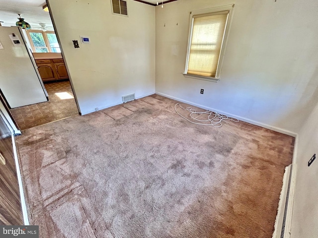 empty room featuring ceiling fan and light colored carpet