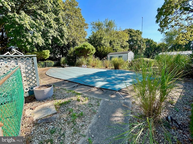 view of pool featuring a patio and a storage unit