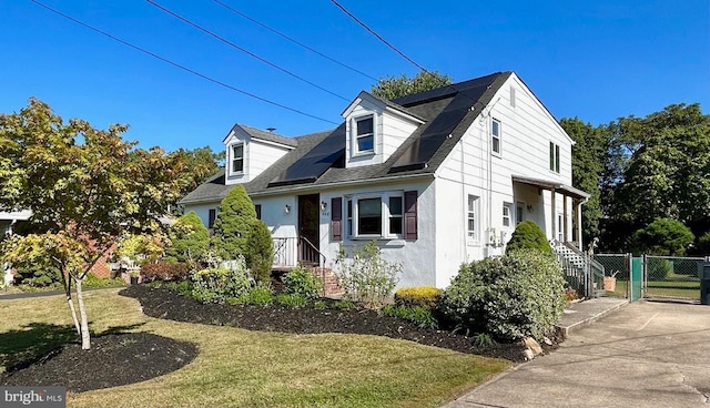 view of side of home with solar panels and a lawn