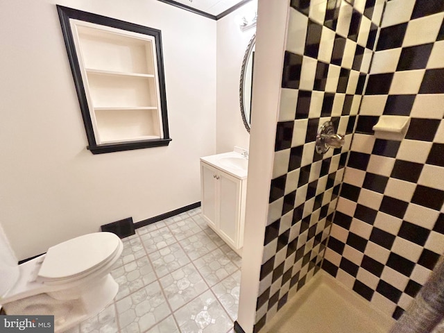 bathroom featuring a tile shower, tile patterned flooring, vanity, and toilet