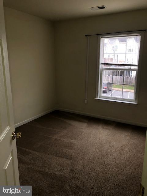 empty room featuring dark colored carpet