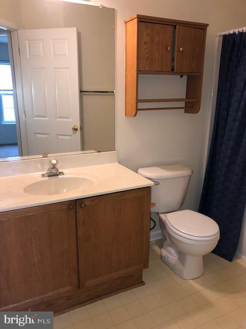 bathroom featuring tile patterned flooring, vanity, and toilet