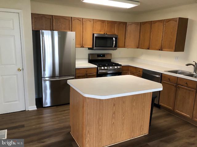 kitchen featuring dark hardwood / wood-style floors, a kitchen island, and stainless steel appliances