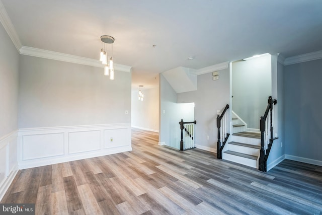 unfurnished room with a chandelier, crown molding, and wood-type flooring