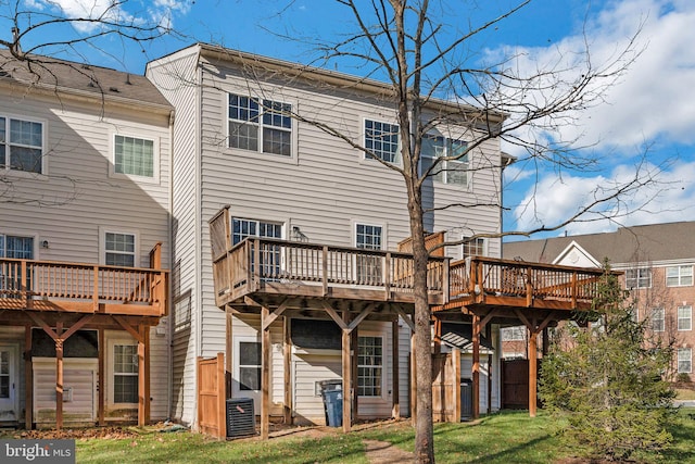 rear view of house with a deck and a yard