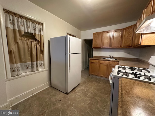 kitchen featuring sink, white appliances, and ventilation hood