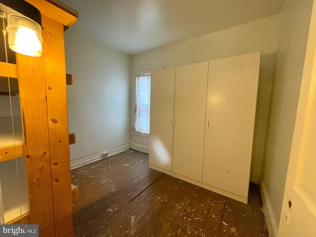 unfurnished bedroom with dark wood-type flooring