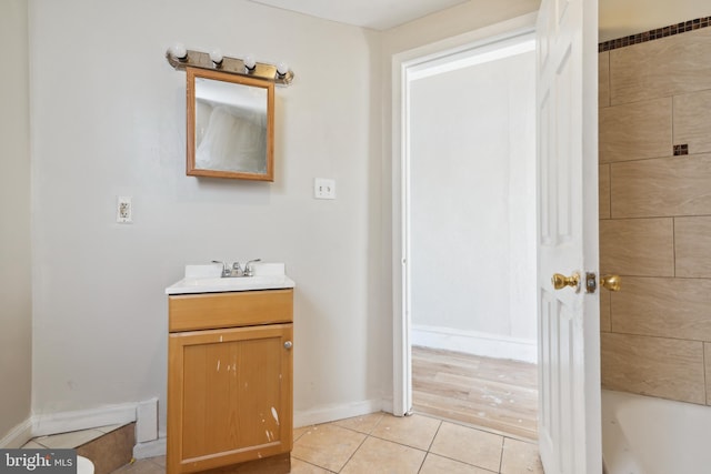 bathroom with tile patterned floors, vanity, and a bath