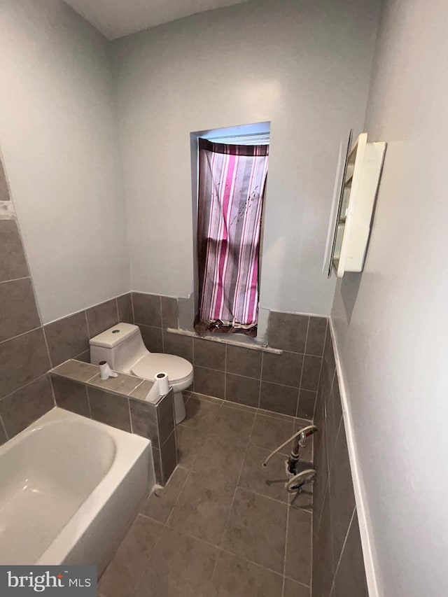 1723 N 53rd St, Philadelphia, PA 19131 - bathroom featuring a bath, toilet, tile walls, tile patterned flooring, and wainscoting