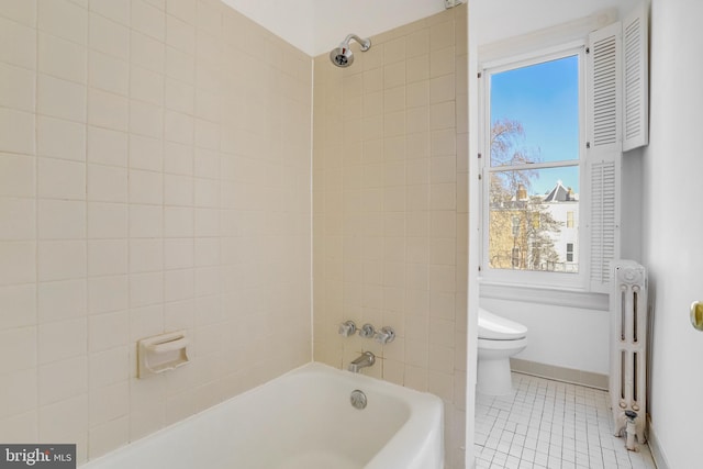 bathroom with tile patterned floors, toilet, tiled shower / bath, and radiator