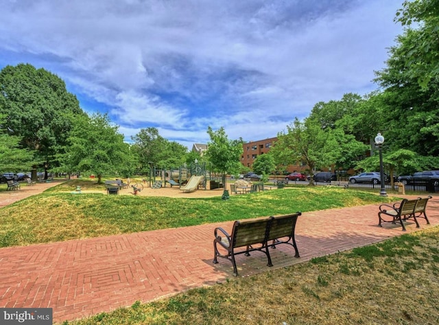 surrounding community featuring a playground and a lawn