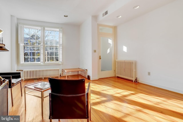 interior space with radiator heating unit and hardwood / wood-style floors