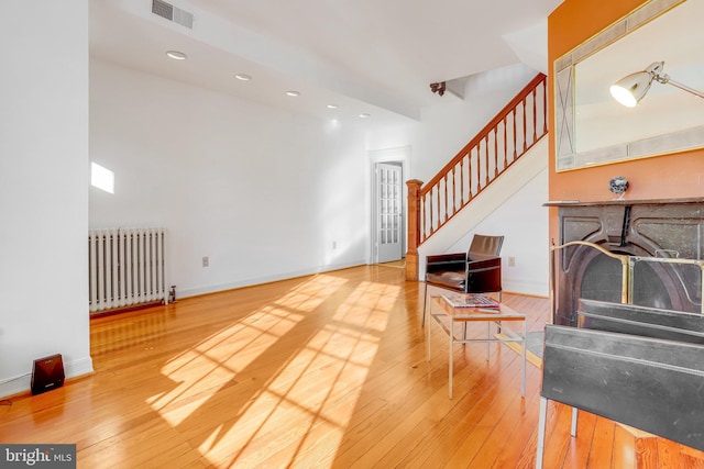 136 E St SE, Washington, DC 20003 - living area featuring radiator heating unit, stairs, wood-type flooring, and recessed lighting