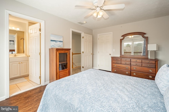 bedroom with ceiling fan, sink, ensuite bathroom, and light hardwood / wood-style flooring