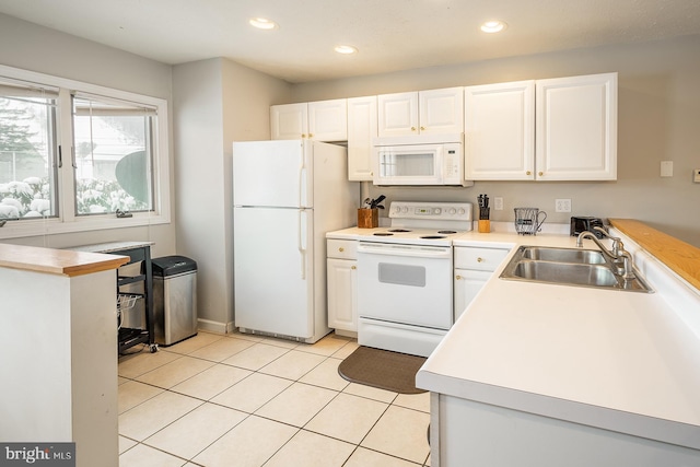 kitchen featuring white cabinetry, sink, light tile patterned flooring, and white appliances