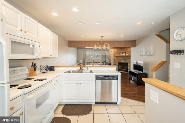 kitchen with white cabinetry, sink, hanging light fixtures, and white appliances