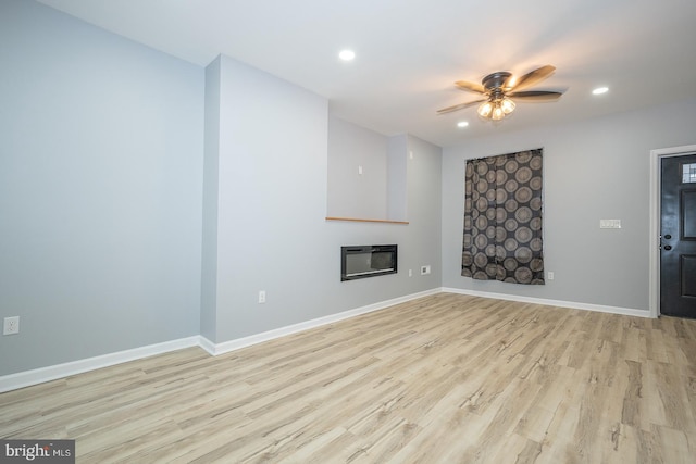 unfurnished living room with light wood-type flooring, heating unit, and ceiling fan