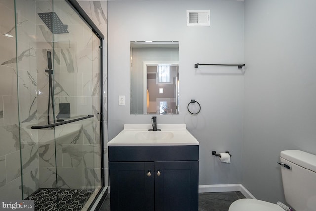 bathroom with vanity, toilet, and a shower with shower door