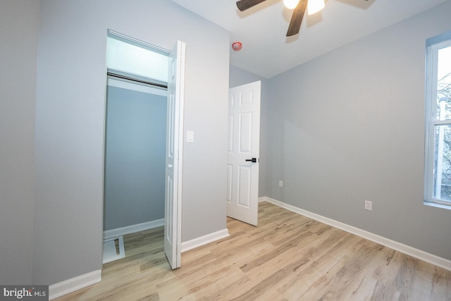 unfurnished bedroom featuring multiple windows, ceiling fan, a closet, and light hardwood / wood-style floors