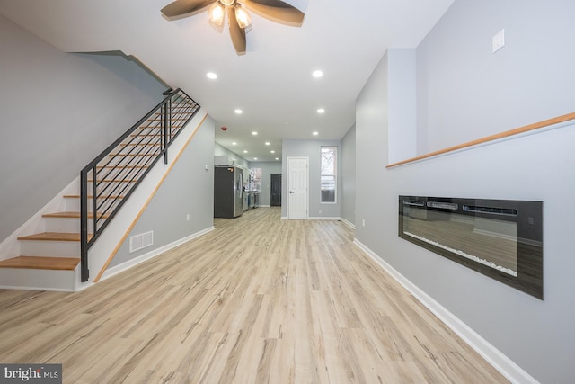 unfurnished living room with ceiling fan and light hardwood / wood-style floors