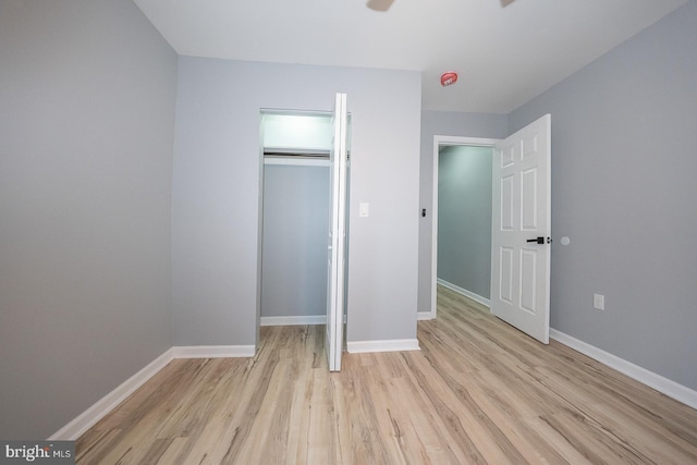 unfurnished bedroom featuring a closet and light wood-type flooring